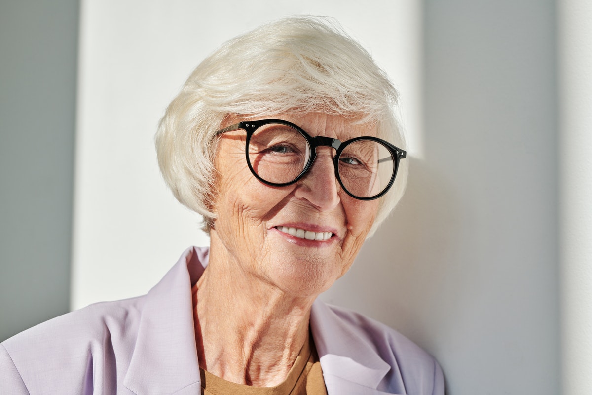 Szemüveges 55 év feletti nő. Az időskori sárgafoltsorvadás tünetei és kockázati tényezői