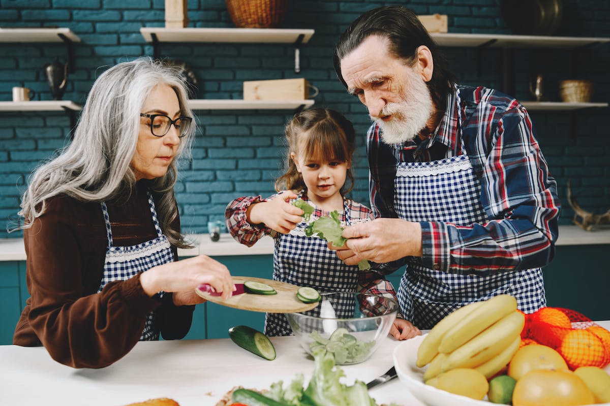 Egy kislány a nagyszüleivel ételt készít elő. Így támogassuk gyermekeink immunrendszerét a hidegebb hónapokban